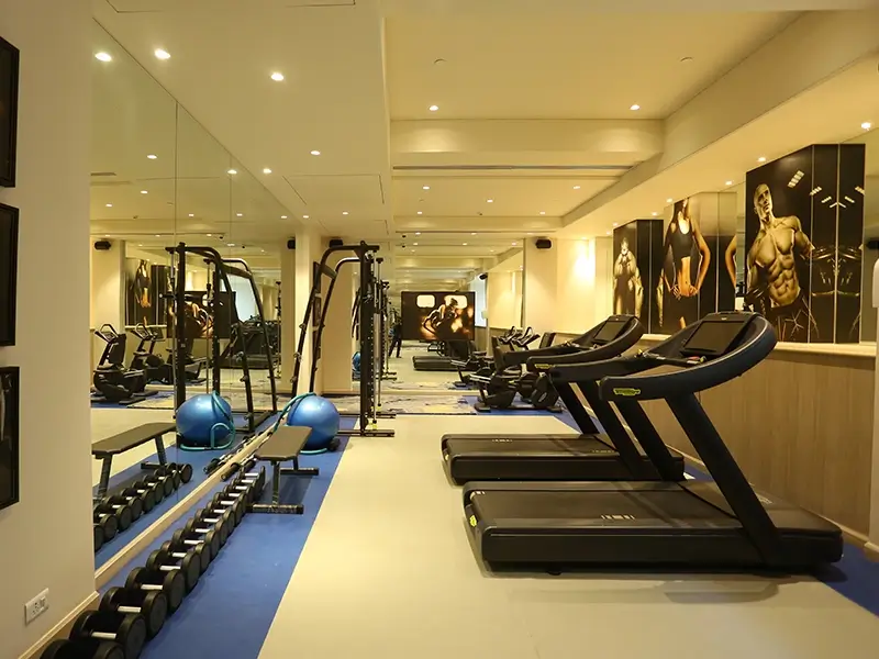 Well-equipped fitness center with modern gym machines, equipment, and wide range of options available to workout.